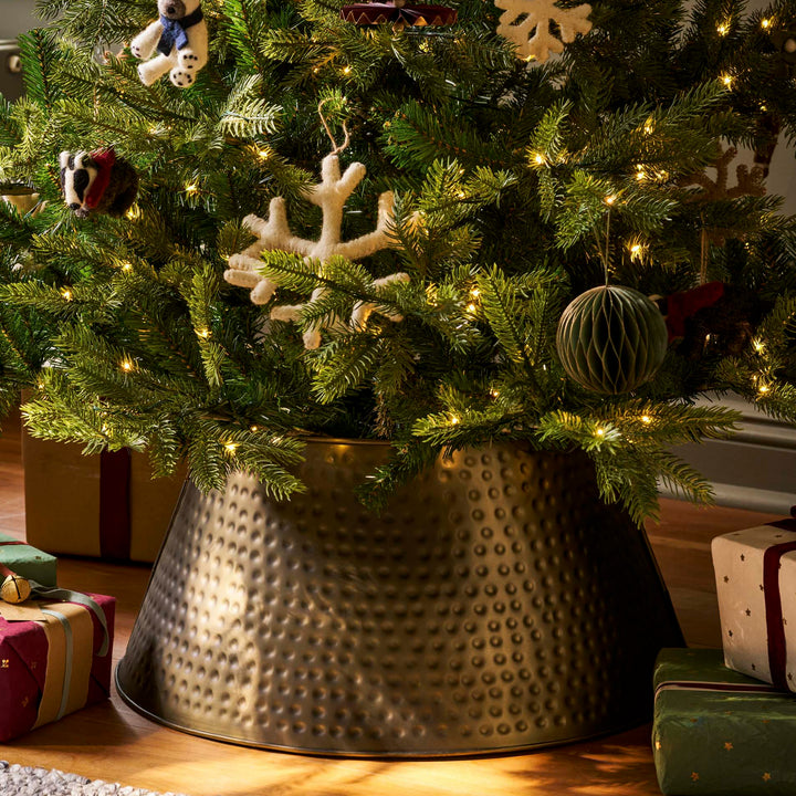 Hinksey antique brass tree skirt beneath a decorated Christmas tree