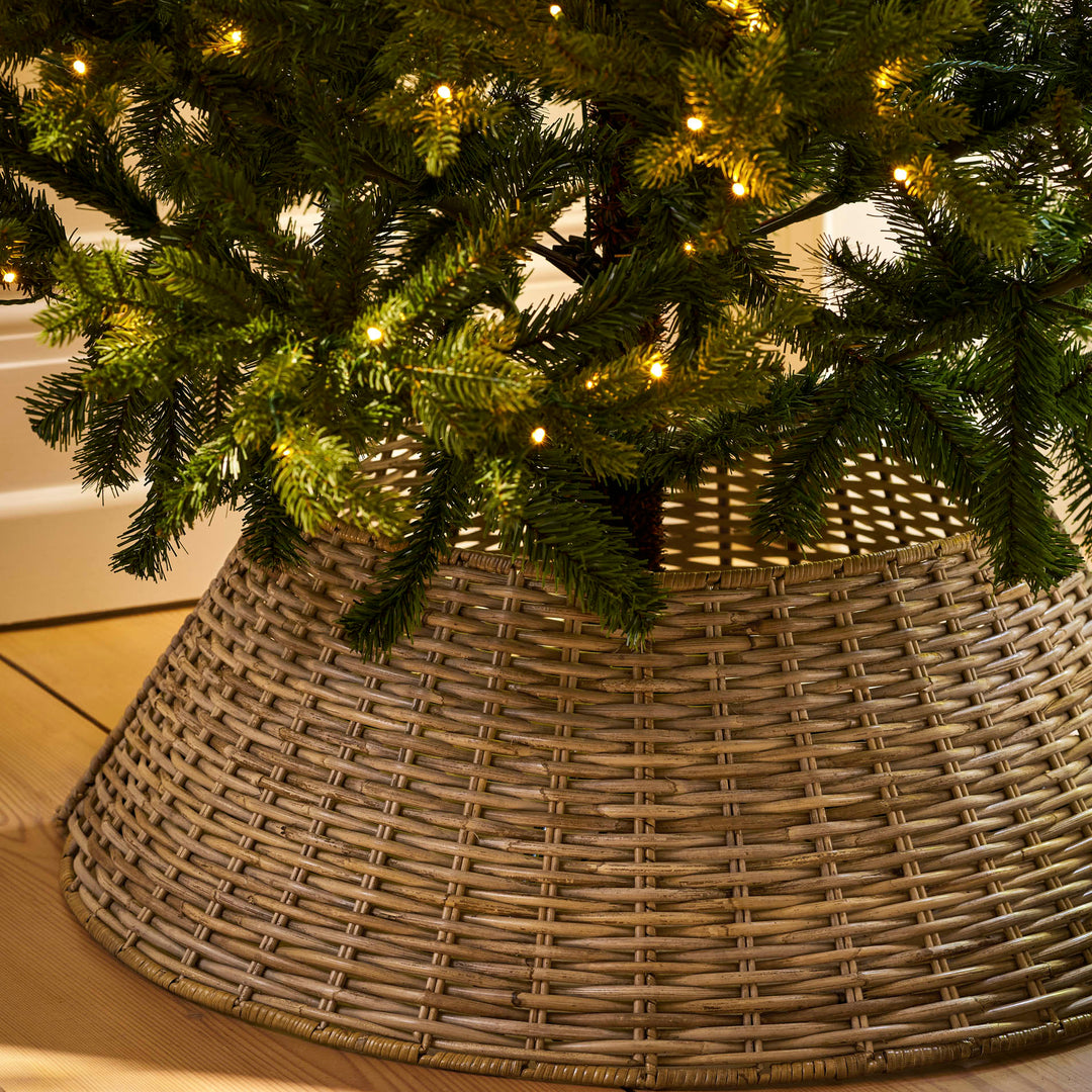 Bembridge large natural rattan tree skirt beneath a decorated Christmas tree